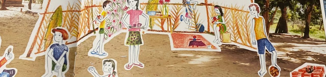 Ilustrações recortadas de crianças e de uma casa montadas sobre a areia, do projeto de literatura no Pantanal com Roberta Asse